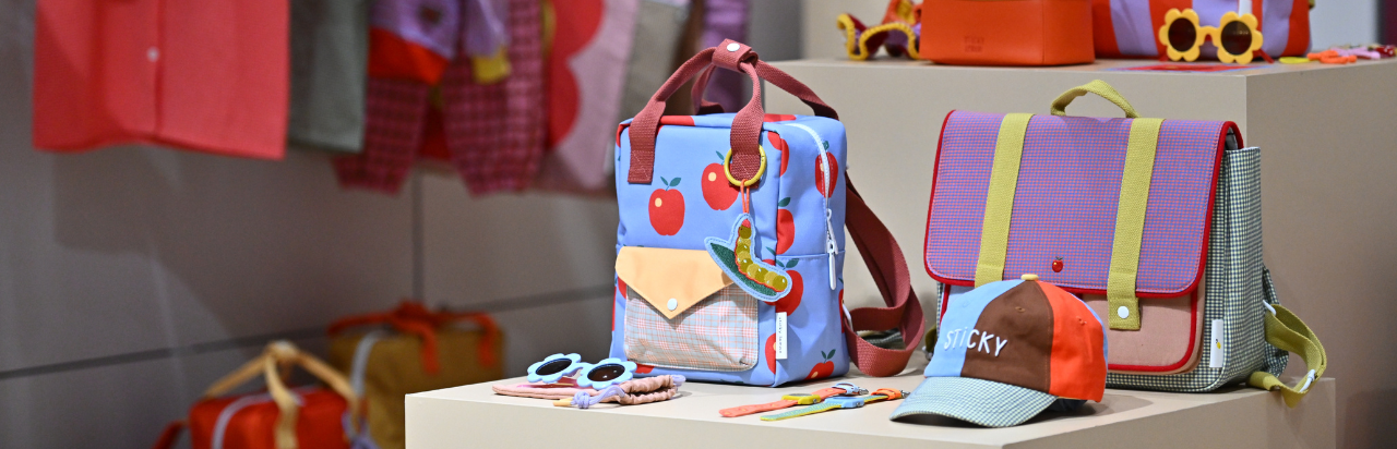 colorful children's clothes hanging on the wall at the CBME Türkiye exhibition.
