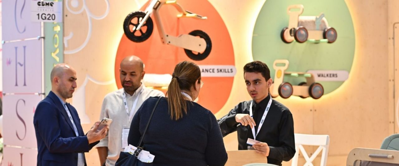 An attendee at the CMBE Turkey exhibition examining the tag on a pair of children's pants.