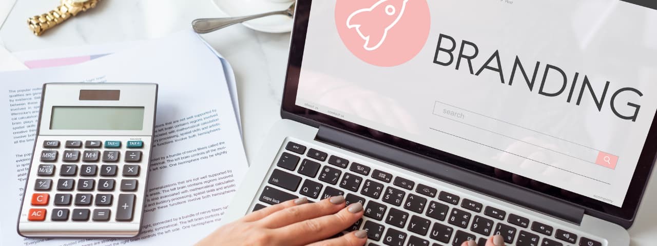 Yakında ofis kağıtlarının üzerinde duran bir hesap makinesinin bulunduğu, marka bilinci oluşturma başlangıç ​​ekranını gösteren bir dizüstü bilgisayar.